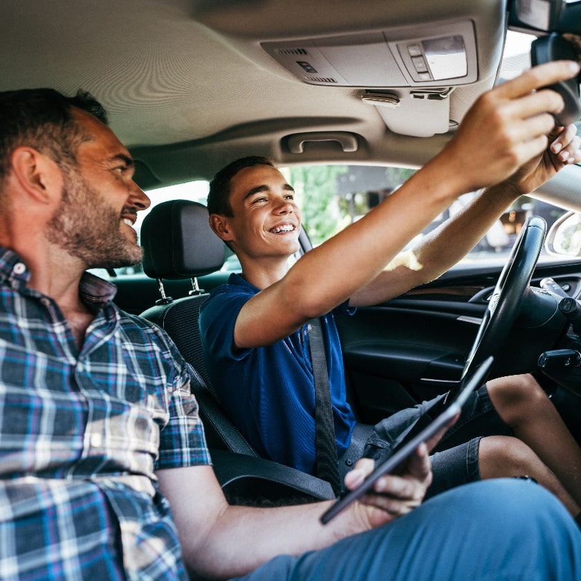 Driving instructor sitting his student and explain to him car driving basics, how to properly prepare himself for a drive. View from inside.