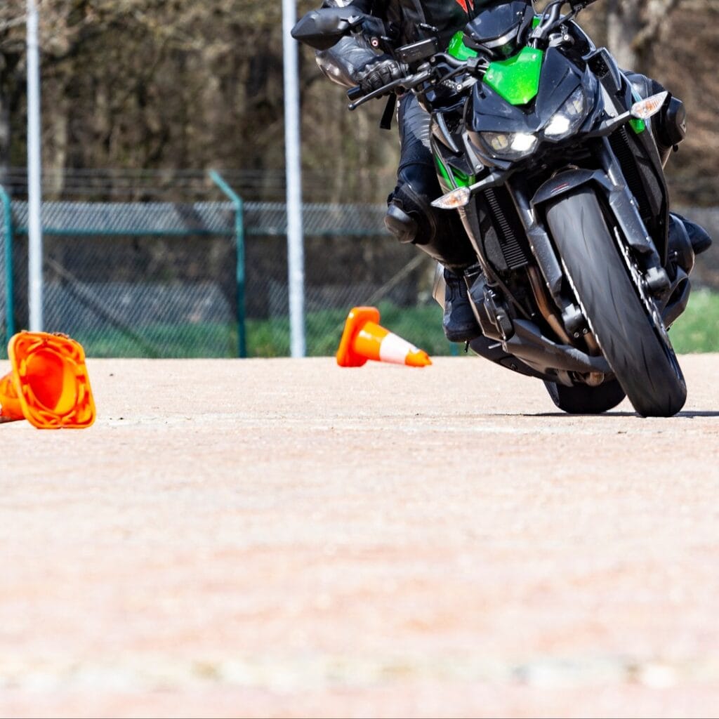 Motorradfahrer in Schräglage fährt Slalom bei Fahrsicherheitstraining zum Start der Motorrad Saison